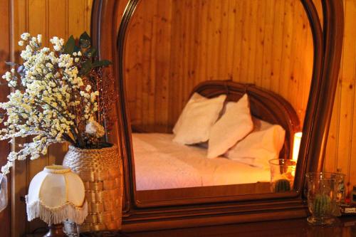 um espelho numa mesa com uma cama num quarto em Wildwood Cottage em Serramazzoni