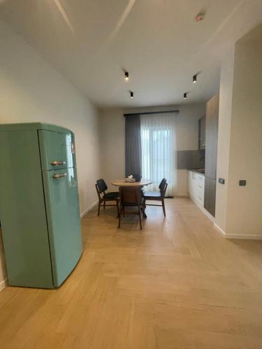 a kitchen and dining room with a table and a green refrigerator at Aurora Luxe in Dilijan