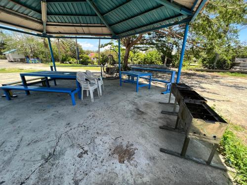 two blue picnic tables and chairs under a pavilion at Kenting Dajianshan Cabin in Kenting