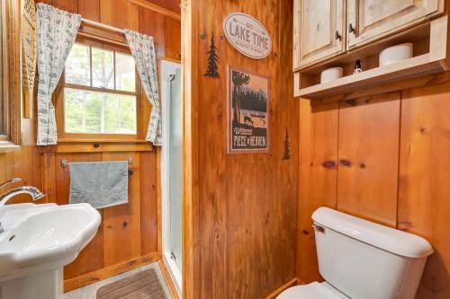 a bathroom with a toilet and a sink at Cozy Carp Lake Cottage with Dock, 4 Kayaks and Fire Pit in Carp Lake