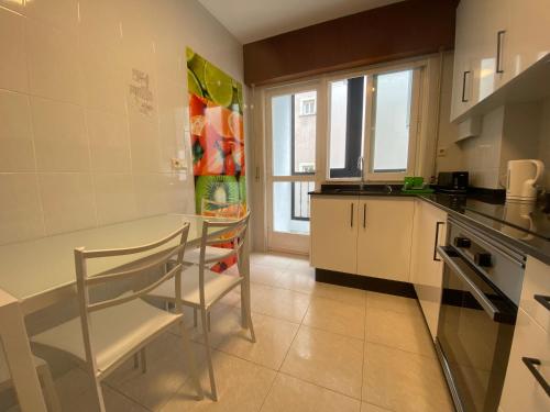 a kitchen with a table and some chairs in it at LALIN CENTRO URBANO, CÓMODO Y FUNCIONAL in Lalín