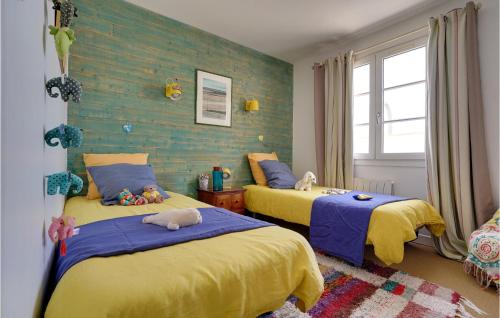 1 dormitorio con 2 camas de color amarillo y azul en 2 Bedroom Pet Friendly Home In Rivedoux-plage, en Rivedoux-Plage