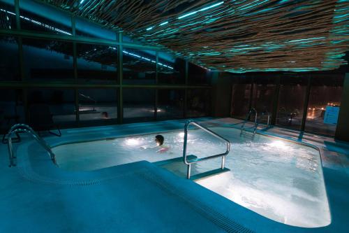 una persona nadando en una piscina por la noche en Hotel Bellavista, en Puerto Varas