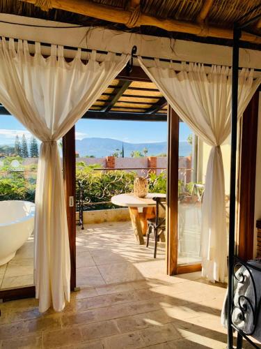 a patio with white curtains and a table with a view at Casa Miura Hotel Boutique in Ajijic