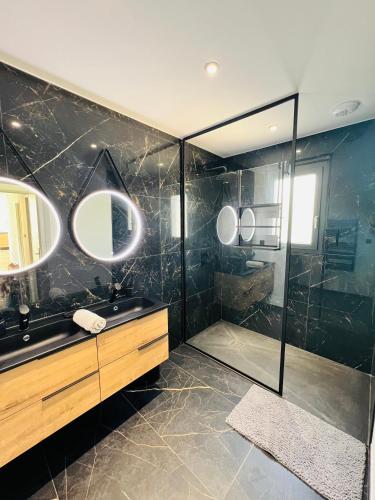 La salle de bains est pourvue de 2 lavabos et d'une douche avec miroirs. dans l'établissement Villa Pescalune, à Lunel