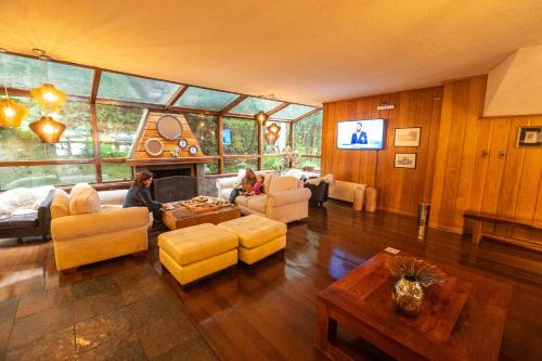 a woman sitting in a living room with a fireplace at Hotel Bellavista in Puerto Varas