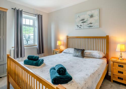 a bedroom with a bed with two towels on it at Hafod Ganol Farm in Trehafod