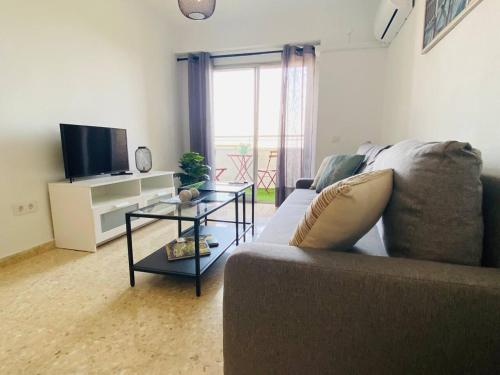 ein Wohnzimmer mit einem Sofa und einem TV in der Unterkunft NICE Apartment Close To The BEACH in Valencia