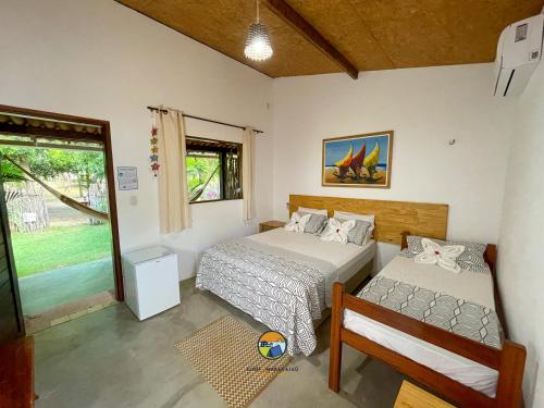 um quarto com 2 camas, uma cadeira e uma janela em Aldeia Maracajaú - Camping & Chalés em Maracajaú