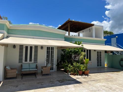 a house with a patio with chairs and an umbrella at Aguada Beach Condos in Aguada