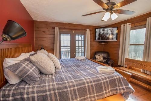 una camera da letto con un letto e un ventilatore a soffitto di Mountain Skye Lodge a Banner Elk
