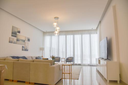 a living room with a couch and a tv at Seascape Villa in Fujairah