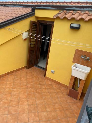 a yellow house with a sink on the side of it at CASA VACANZA DAMAR in Mascali