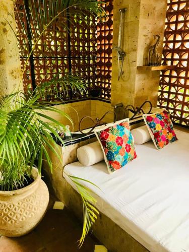 a bed with two pillows on it next to a plant at Casa Miura Hotel Boutique in Ajijic