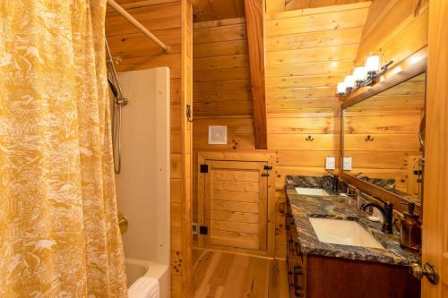 La salle de bains en rondins est pourvue de 2 lavabos et d'une douche. dans l'établissement Stoney Brook Cabin, à Boone