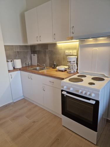 a kitchen with a white stove and a sink at Above Apartments near the Airport in Artemida