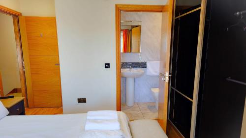ein kleines Bad mit einem Bett und einem Waschbecken in der Unterkunft St Martins House Apartments in Tranent