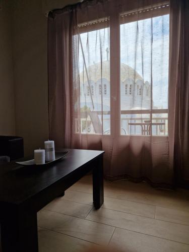 a table and a window with a view of a building at Above Apartments near the Airport in Artemida