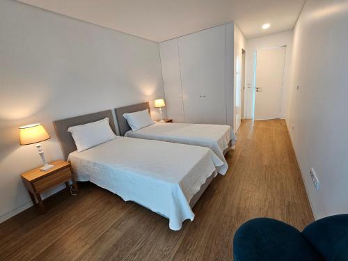 um quarto de hotel com duas camas e duas lâmpadas em Galé T3 em Caloura