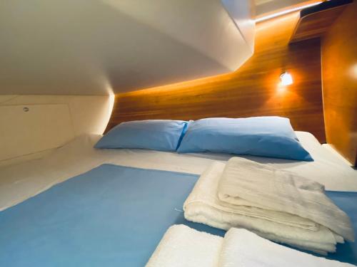 een slaapkamer met een bed met blauwe lakens en kussens bij Boat and Breakfast in Palermo