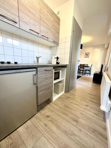 una cucina con pavimenti in legno e pareti bianche di Aux portes de Strasbourg a Mundolsheim