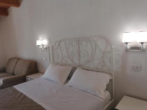 1 dormitorio con cama, silla y luces en Agriturismo Valle Dei Gelsi, en Peschici