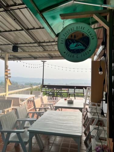 a sign for a restaurant with tables and chairs at บ้านภูไผ่ ไร่ภูไผ่เบิกตะวัน in Ban Nam Phang