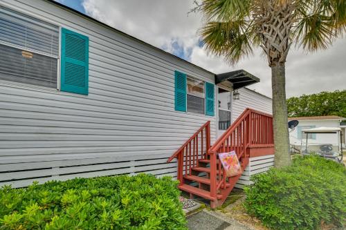 a house with a staircase next to a palm tree at Walk to Shore Myrtle Beach House with Private Deck! in Myrtle Beach