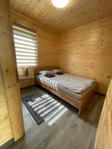 Brzozowy Zakątek Zator في زاتور: غرفة بسرير في كابينة خشبية
