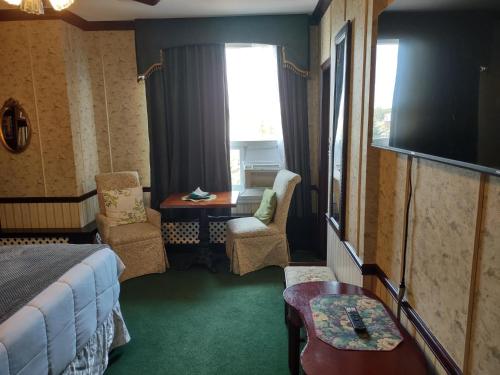 a hotel room with a bed and a table and chairs at The King George Inn in Cobourg