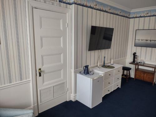 a room with a white door and a sink at The King George Inn in Cobourg