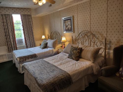 a hotel room with two beds and a couch at The King George Inn in Cobourg