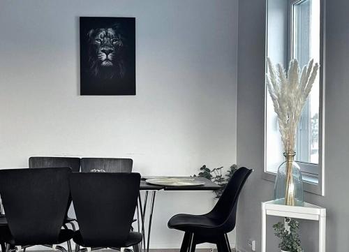 ein Esszimmer mit einem Tisch mit Stühlen und einem Löwenbild in der Unterkunft New Magnificent view apartment Near the centre in Tromsø