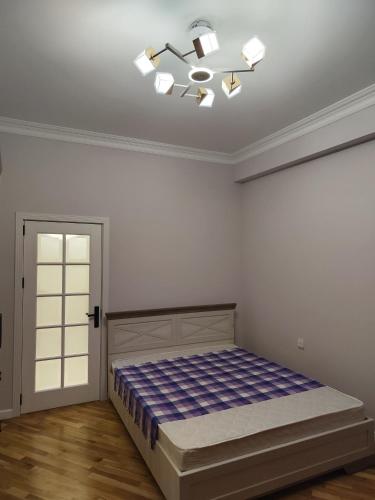 a bedroom with a bed and a chandelier at Life is amazing in Baku