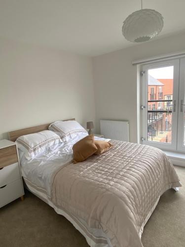 Modern 3 Bed Town House Marina Hull في هال: غرفة نوم بيضاء بها سرير ونافذة
