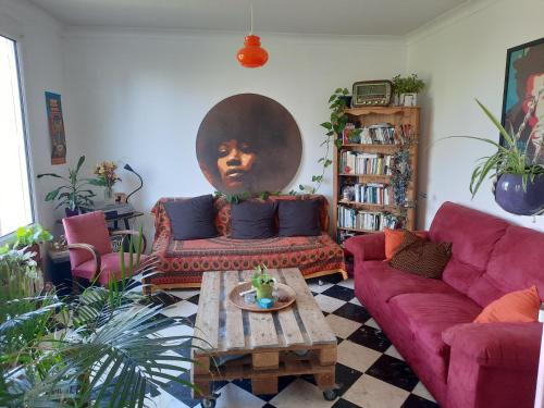 uma sala de estar com um sofá vermelho e uma grande cabeça na parede em Family home proche circuit em Le Mans