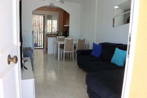 a living room with a black couch and a table at Cozy Villa in Campasol with private pool in Mazarrón