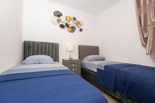 a bedroom with two beds and a wreath on the wall at Sea star Apartment in Tivat