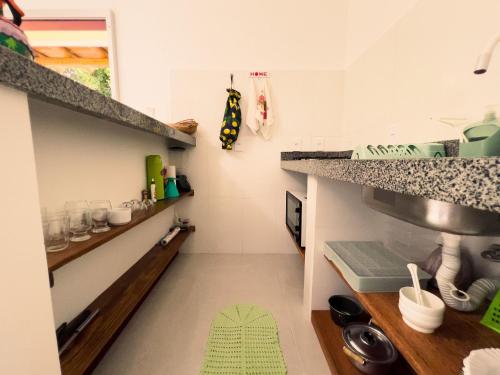 een keuken met een aanrecht en een groen kleed op de vloer bij Sítio de Praia in Arraial d'Ajuda