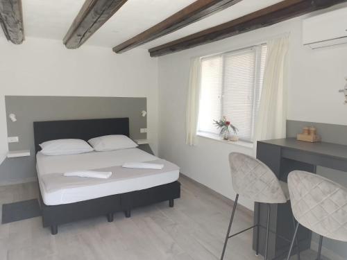 een slaapkamer met een bed en een tafel en stoelen bij Apartments Ciao Bella city centre with free parking in Šibenik