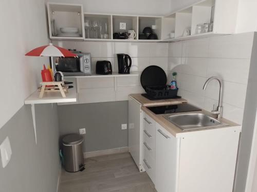 een kleine witte keuken met een wastafel en een aanrecht bij Apartments Ciao Bella city centre with free parking in Šibenik