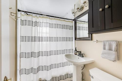 a bathroom with a sink and a shower curtain at Modern Alexandria Townhome about 2 Mi to Old Town! in Alexandria