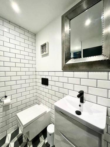 a bathroom with a sink and a toilet and a mirror at Duplex Apartment Harbourside city centre in Bristol
