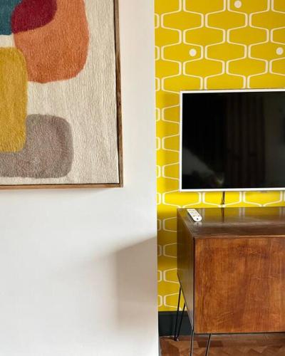 a tv sitting on top of a table next to a painting at Duplex Apartment Harbourside city centre in Bristol