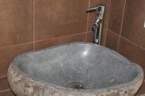 a stone sink in a bathroom with a faucet at Les Hauts du Plateau in Châtillon