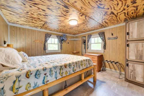 a bedroom with a bed and a wooden ceiling at Waterfront Paradise Lake Cottage with Pvt Dock! in Carp Lake