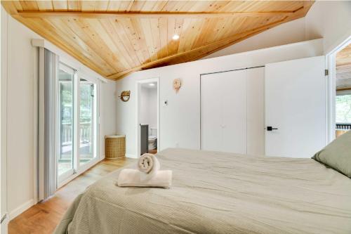 a bedroom with a large bed with a wooden ceiling at Pocono Pines Penthouse with Private Deck! in Pocono Pines
