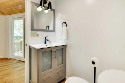 y baño con lavabo y espejo. en Pocono Pines Penthouse with Private Deck!, en Pocono Pines