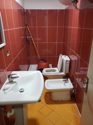 a bathroom with a white sink and a toilet at Altiku Apartments in Golem