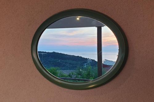 a round window in a wall with a sunset at Pure Blue House in Athanion
